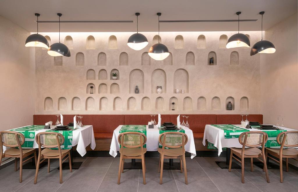 Vox Maris Resort elegantā restorāna interjers ar zaļām galdautām.