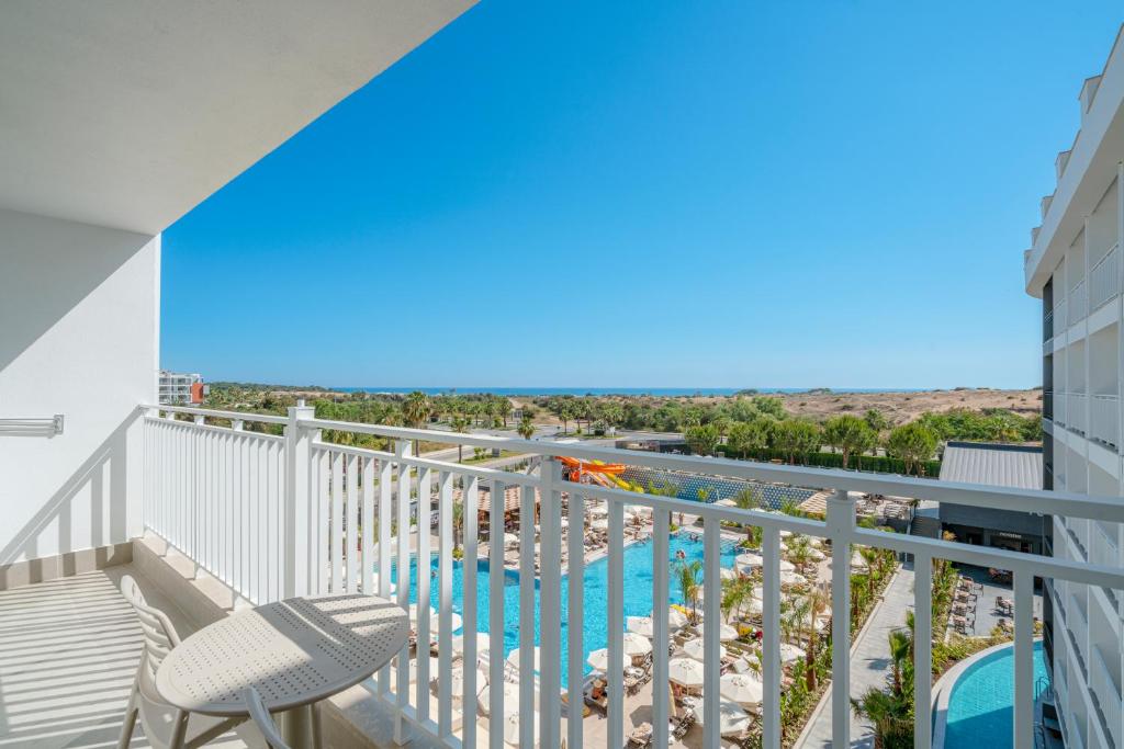Skats no balkona uz Vox Maris Resort baseinu un jūru piekrastē.