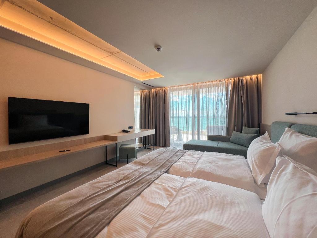 Moderns viesnīcas numurs ar divām gultām, televizoru un elegantu interjeru, kas nodrošina ērtu atpūtu. Lielie logi piedāvā skatu uz āra telpu.