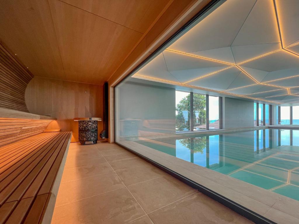 Mūsdienīga pirts ar koka apdari un stikla sienām, kas nodrošina skatu uz baseinu un dabu. Interjers ir elegants un relaksējošs, ideāli piemērots atpūtai.
