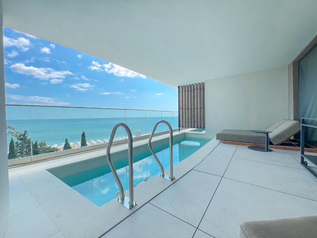 Modernas terases ar privātu baseinu un skatu uz jūru, ideāla vieta relaksācijai. Gaišs interjers ar minimālistiskām līnijām un plašām stikla durvīm.