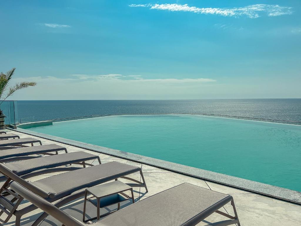 Peldbaseins ar skatu uz okeānu, apkārt atpūtas krēsli un saulaina debess. Ideāla vieta relaksācijai un atpūtai.
