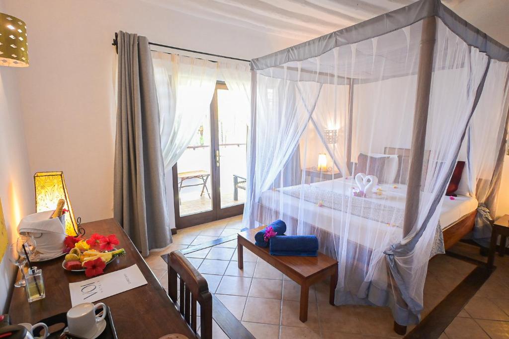 Elegants numurs ar baldahīna gultu viesnīcā VOI Kiwengwa Beach.