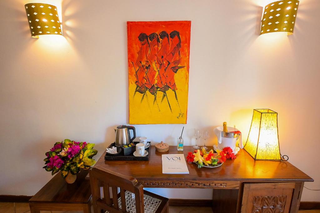 VOI Kiwengwa Beach numura stūrītis ar mākslas darbu un ziediem.