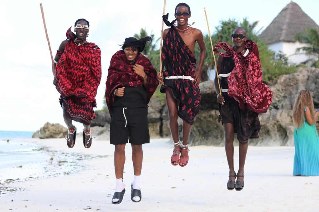 Viesi un vietējie iedzīvotāji pludmalē pie Essque Zalu Zanzibar