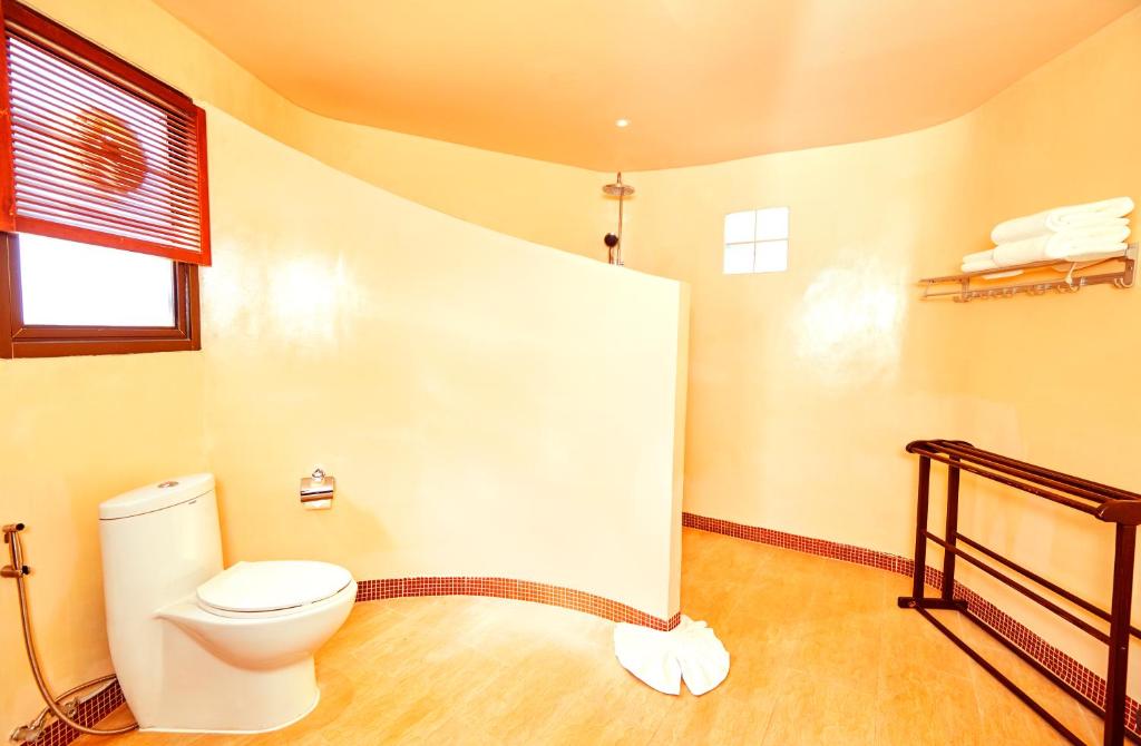 Mūsdienīga vannas istaba ar funkcionālu dizainu, ietverot tualeti, dušu un plauktu dvieļiem. Telpas sienas ir gaišas, radot patīkamu atmosfēru.