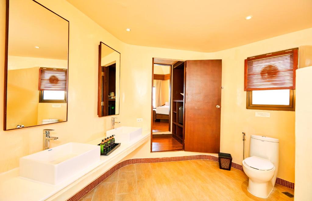 Mūsdienīgs vannas istabas interjers ar divām izsmalcinātām izlietnēm, spoguļiem un komfortablu tualeti, kas rada relaksējošu atmosfēru. Elegants dizains un gaišas krāsas papildina telpas estētiku.