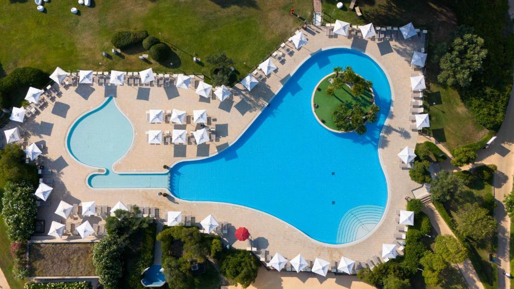 Lielo baseinu ar zilu ūdeni un saulessargiem, kas izvietoti ap to, rotā zaļā zāle. Baseins ir veidots neparastā formā, un tajā ir arī neliela zaļā sala ar augiem.