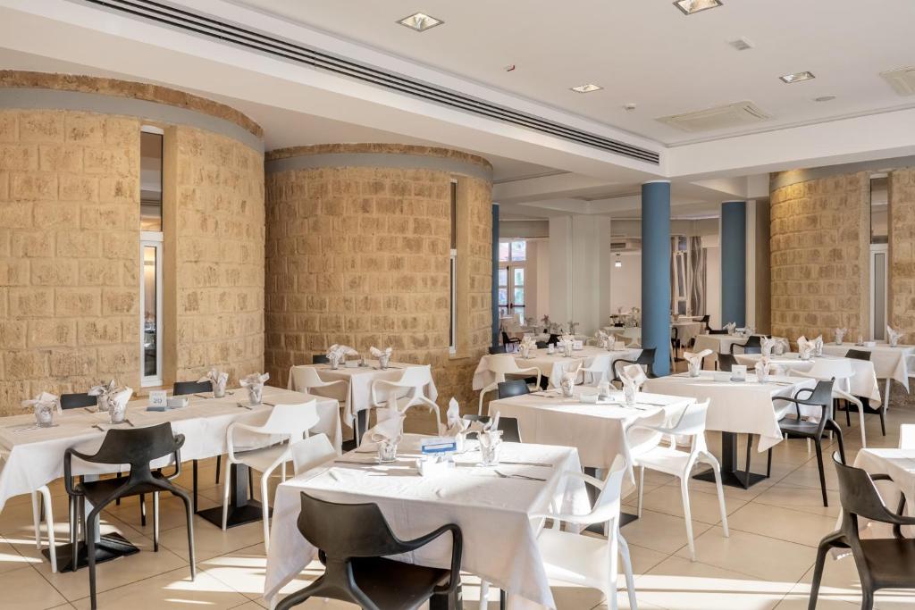 Mūsdienīgs restorāns ar baltām galdautām un stilīgām melnām un baltām krēsliem, akmens sienām un plašu telpu. Ideāla vieta gastronomiskām pieredzēm.