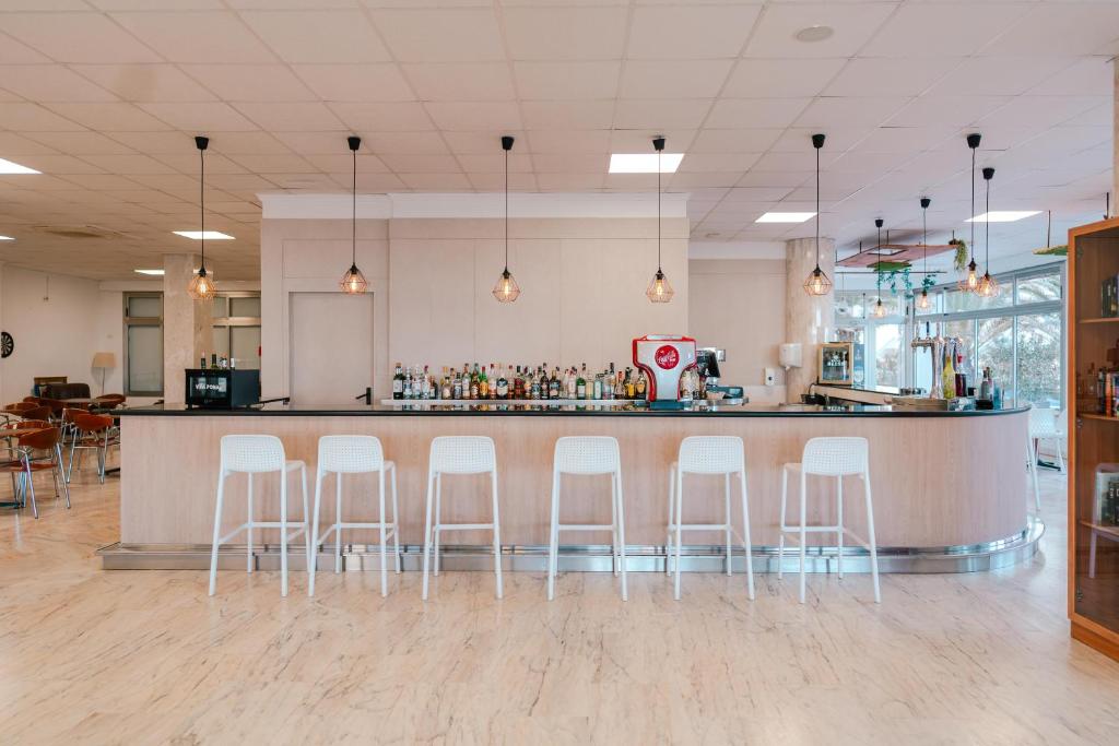 Mūsdienīgs bārs ar stikloto fasādi, kas piedāvā plašu dzērienu izvēli un ērtas sēdvietas. Gaismas piekari un koka akcenti rada patīkamu atmosfēru.