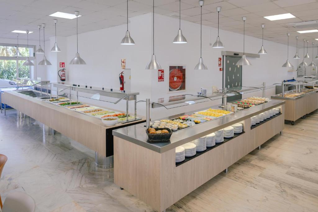 Mūsdienīgs pašapkalpošanās bufete ar plašu ēdienu klāstu, apgaismota ar stilīgām piekārtām lampām. Gaišs un tīrs interjers ar koka mēbelēm un plašām logu ailem.