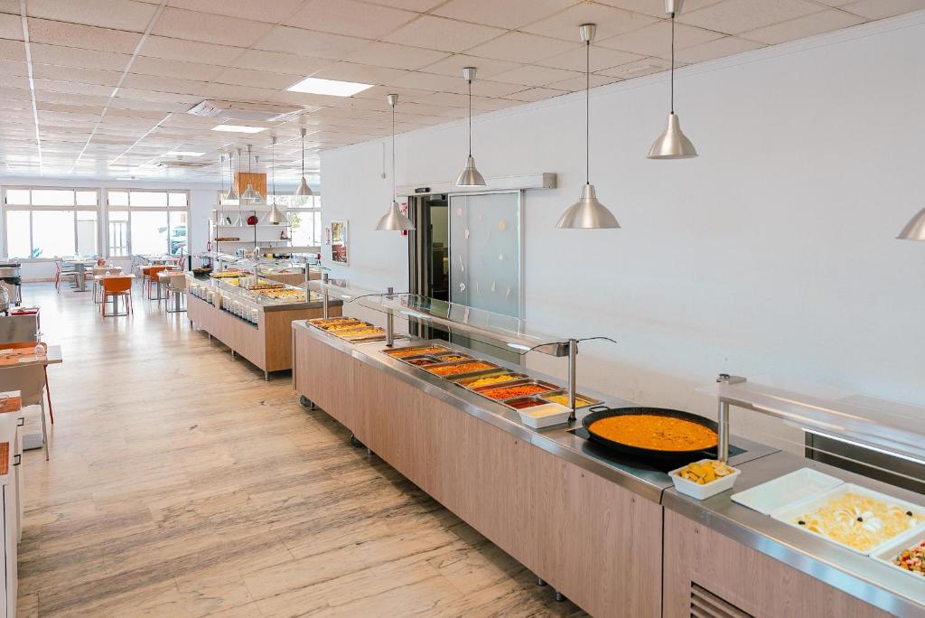 Mūsdienīga pašapkalpošanās ēdnīca ar plašu ēdienu izvēli, kurā ir redzami dažādi trauki un ēdieni. Telpa ir gaiša un plaša, ar koka grīdu un ērtām ēdamzonām.