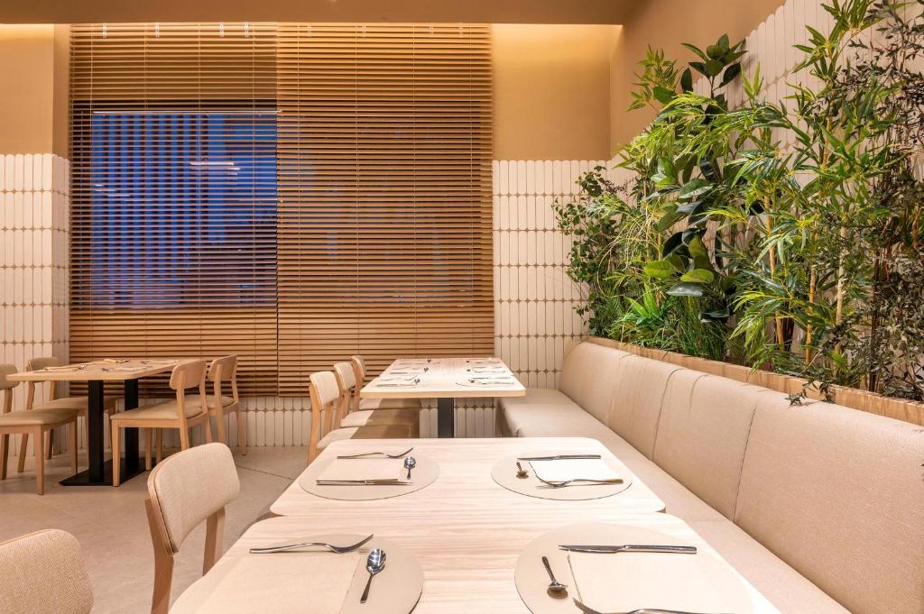 Moderns restorāna interjers ar koka mēbelēm un zaļām augu kompozīcijām. Gaisīgs un ērtas vides noskaņojums, kas aicina uz relaksāciju.