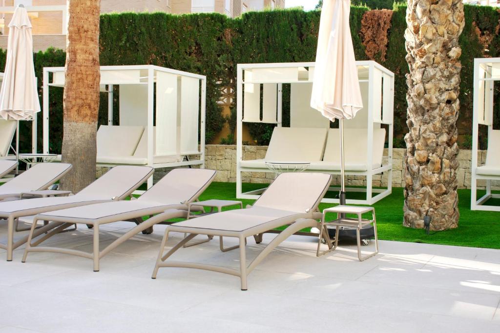 Modernas atpūtas zonas ar sauļošanās krēsliem, baltiem nojumeļiem un palmām, radot relaksējošu atmosfēru. Ideāli piemērota atpūtai pie baseina.