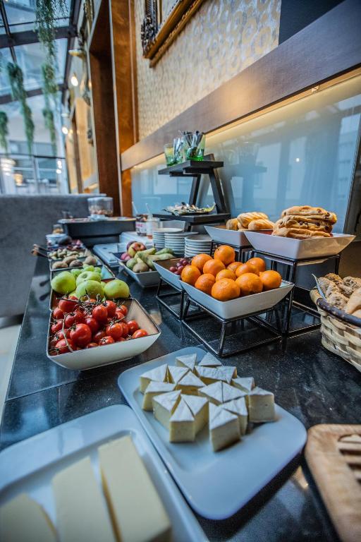 Svaigu augļu un uzkodu bufete, kas piedāvā dažādas ogas, augļus un maizes izstrādājumus, iekārtota modernā telpā.