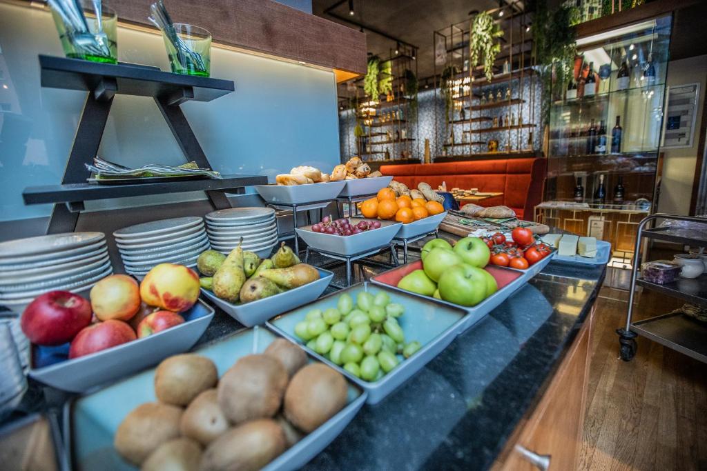 Svaigu augļu un maizes bufete ar dažādām šķīvju un galdu piederumu iespējām, kas atrodas modernā restorānā. 