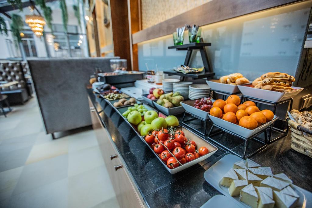 Bagātīgs brokastu bufetes galds ar augļiem, maizi un siera šķēlēm, kas izvietots modernā restorānā. Ideāli piemērots viesmīlības un ēdināšanas tēmām.