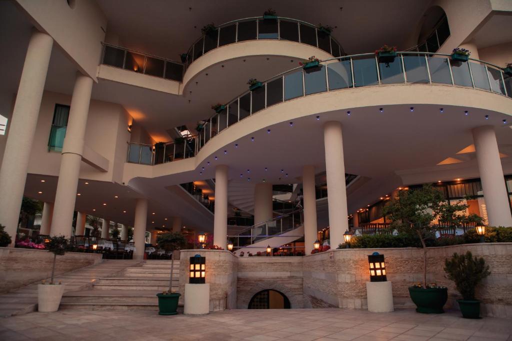 L'ancora Beach Hotel elegantā arhitektūra ar baltiem kolonnām un terasēm.
