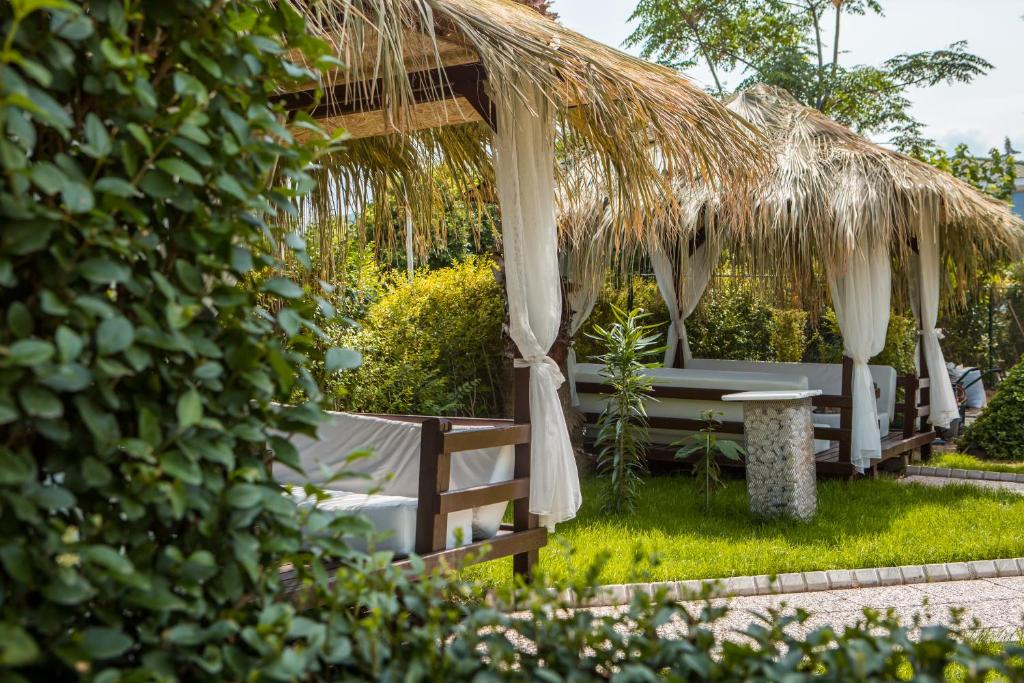 L'ancora Beach Hotel atpūtas zonas ar salmu jumtiem un zaļiem augiem