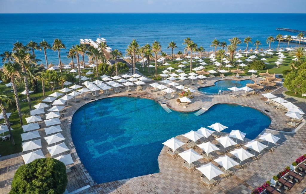 Viesnīcas Voyage Sorgun peldbaseins piekrastē ar saulessargiem