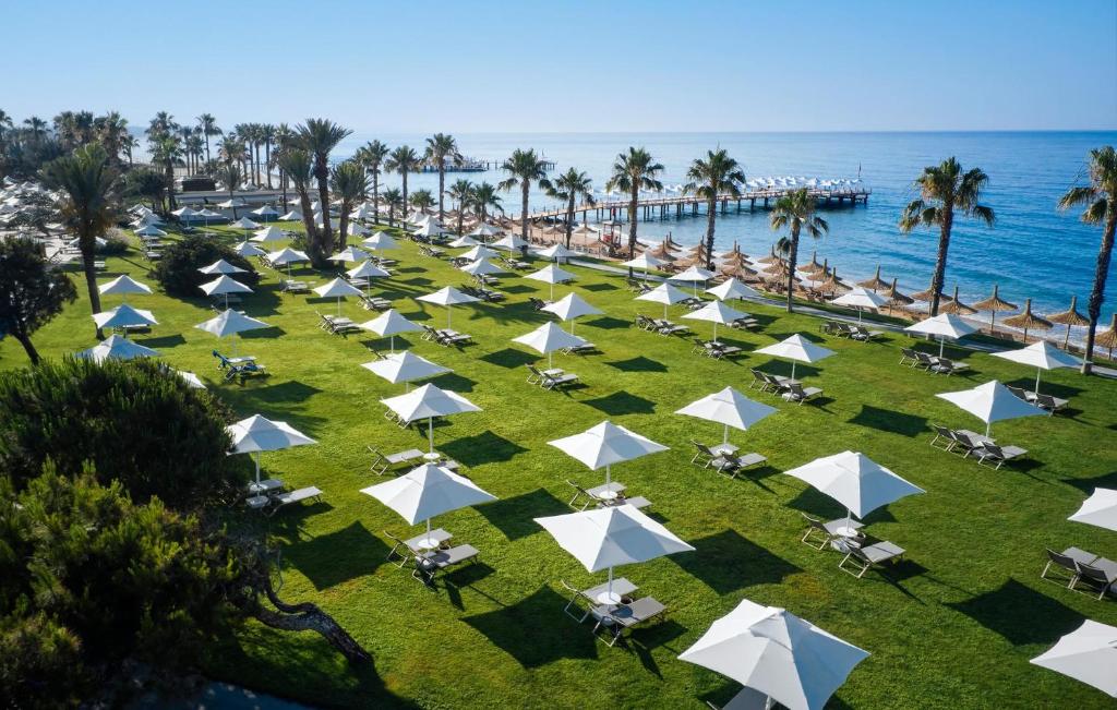 Plašs zāliena laukums ar saulessargiem pie viesnīcas Voyage Sorgun, piekrastē.