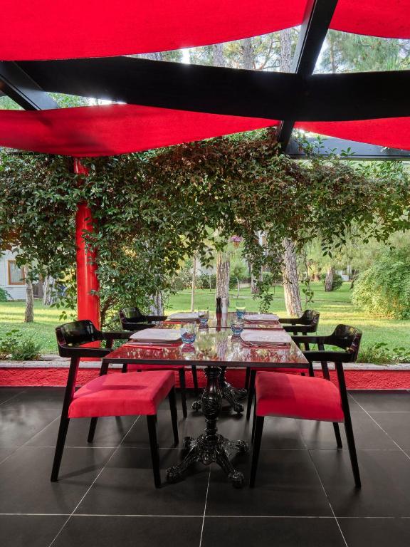 Vietas pie galda ar sarkanām krēslām viesnīcā Voyage Sorgun