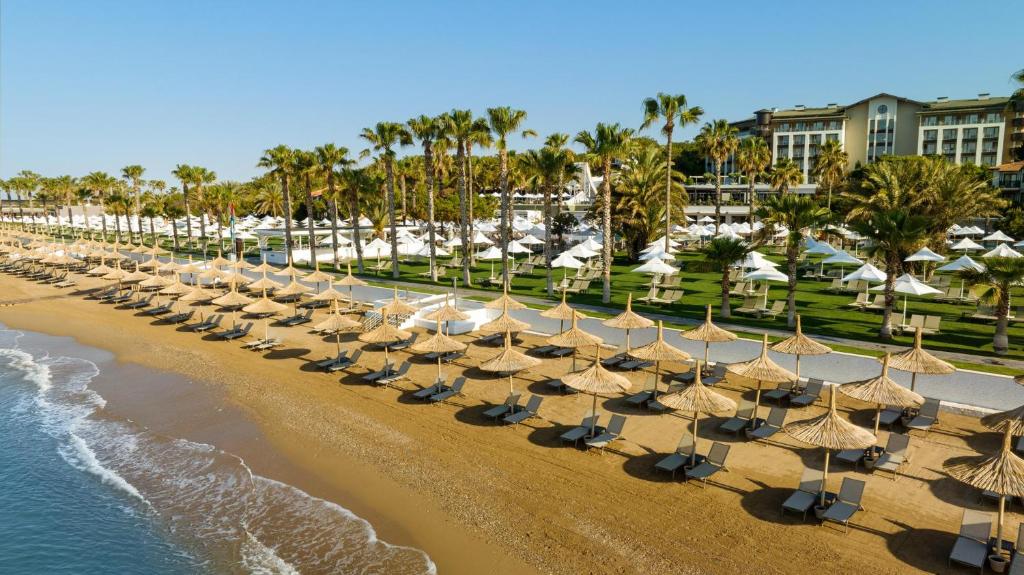 Pludmales zona ar saulessargiem un palmām pie Voyage Sorgun