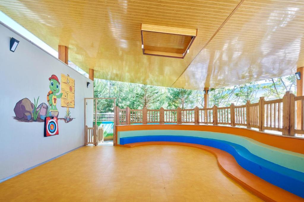 Bērnu rotaļu zona pie viesnīcas Voyage Sorgun ar krāsainām sienām un drošu vidi.