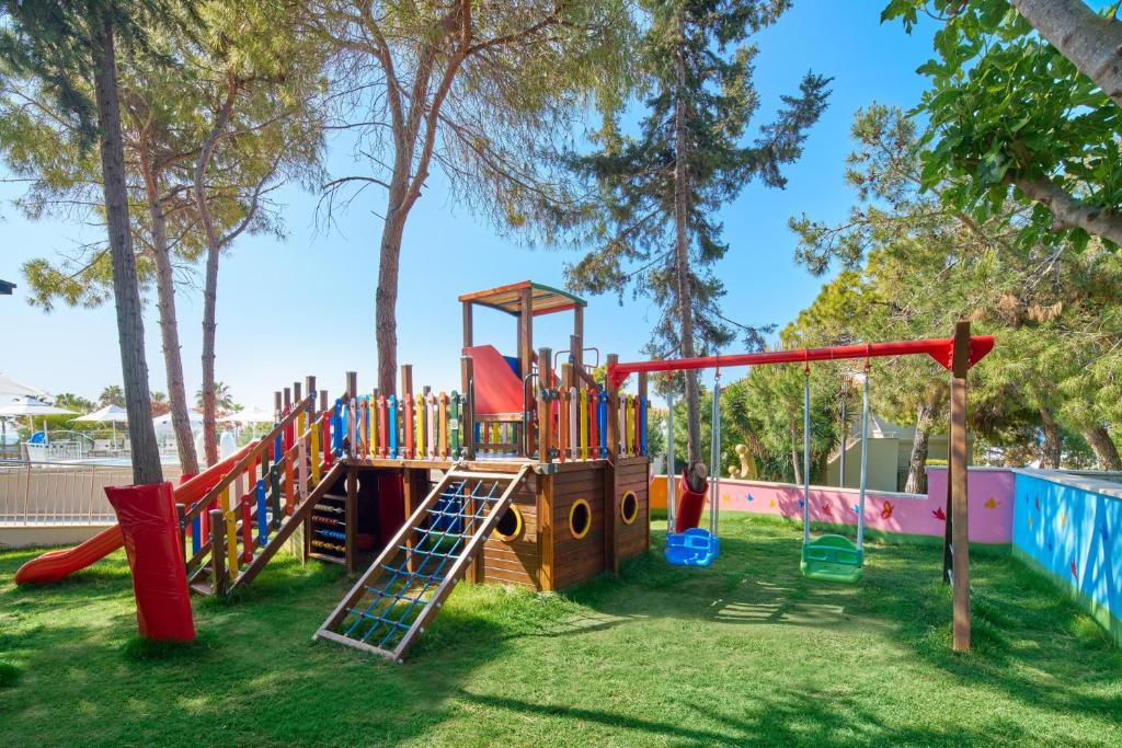 Bērnu spēļu laukums pie viesnīcas Voyage Sorgun ar slaidiem un šūpolēm.