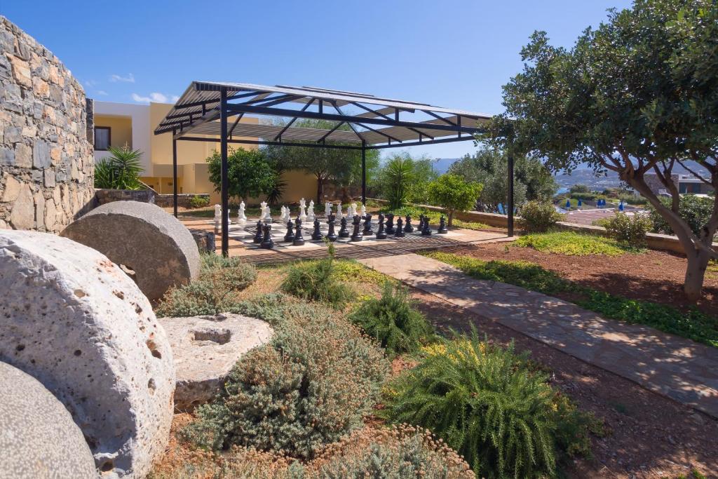 Miramare Resort & Spa dārzs ar lielu šaha galdu un zaļajiem augiem.