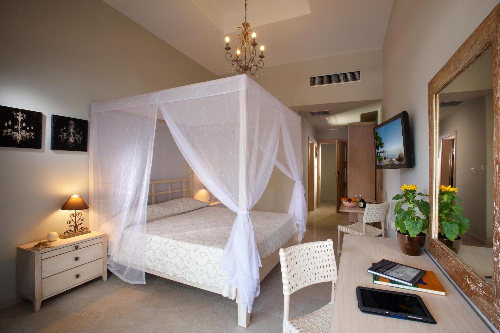 Portes Beach Hotel numurs ar baldahīna gultu, klasisku lustru un koka mēbelēm Halkidiki — elegants interjers ar darba galdu