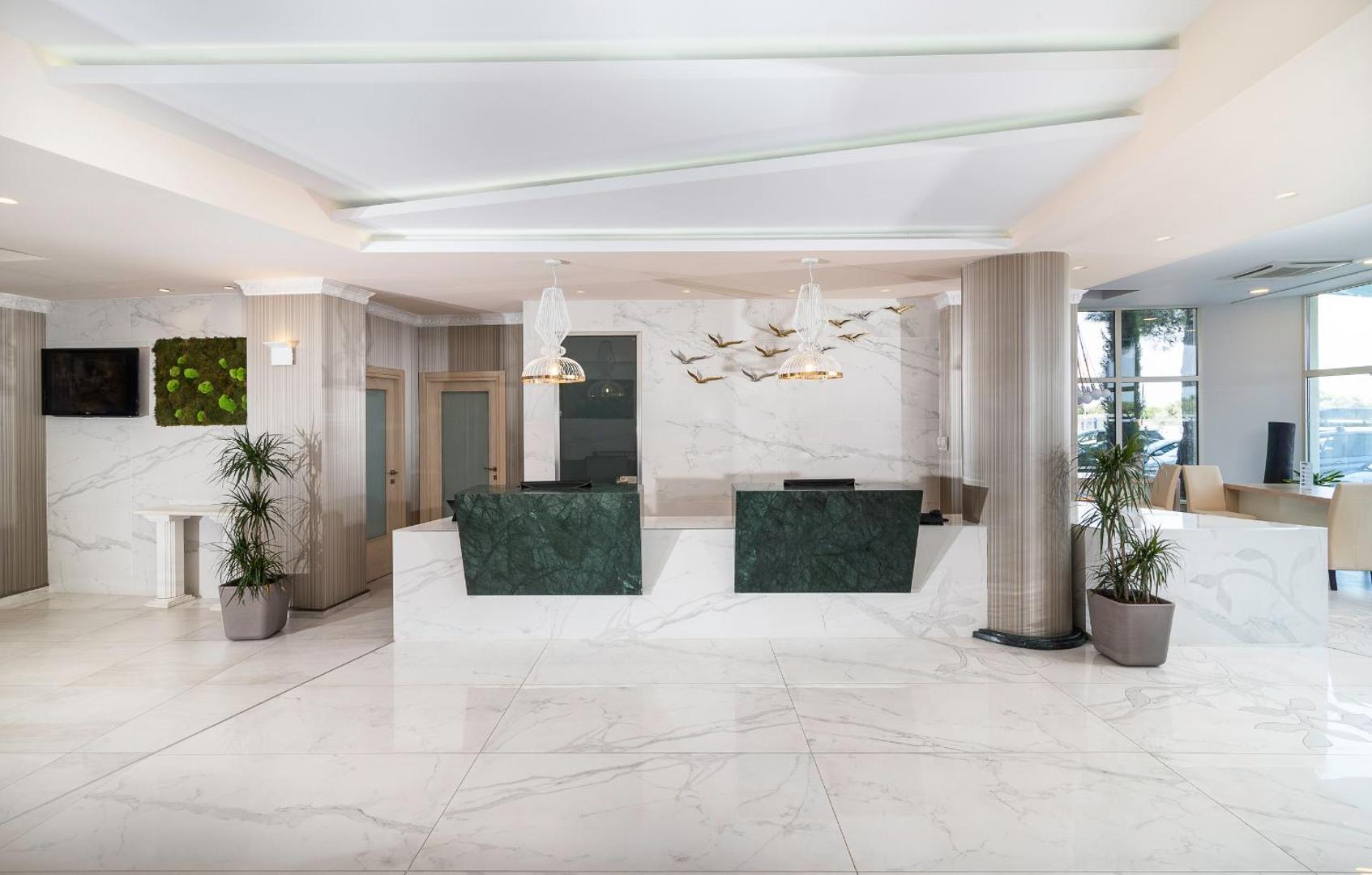 Portes Beach Hotel modernā un gaišā recepcijas zona ar marmora apdari un dizaina elementiem Halkidiki viesnīcā
