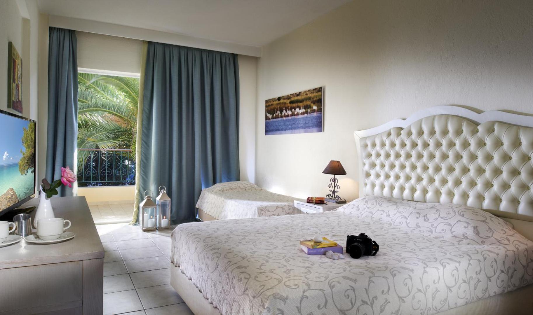 Portes Beach Hotel numurs ar dekoratīvu gultas galvgali, papildu gultu un skatu uz palmām Halkidiki — gaišs un plašs interjers