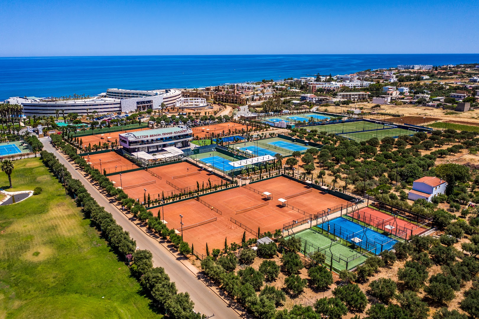 Lyttos Mare viesnīcas un tenisa akadēmijas panorāmas skats no putna lidojuma Hersonisā, Krētā — daudzie tenisa korti pie jūras