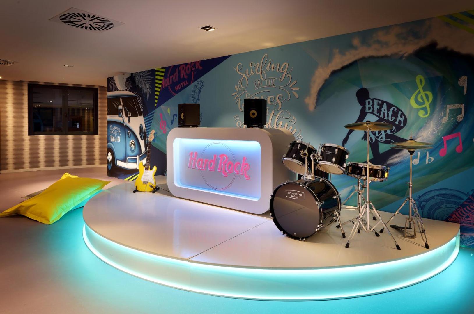 Mūzikas studija un skatuve Hard Rock Hotel Tenerife ar bungu komplektu, ģitāru un izgaismotu dīdžeja pulti bērnu izklaidei.