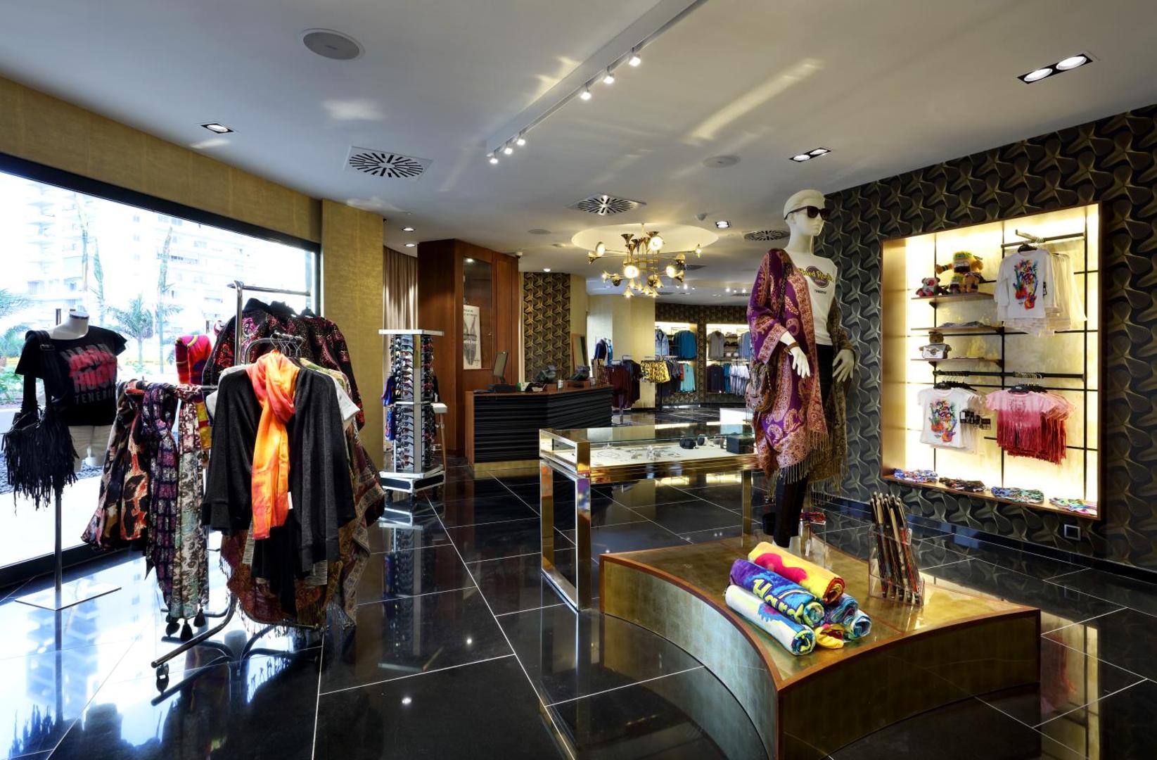 Viesnīcas Hard Rock Hotel Tenerife firmas veikals Rock Shop ar apģērbiem, aksesuāriem un suvenīriem modernā interjerā.
