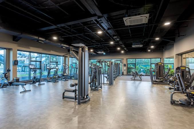 Jacaranda Luxury Resort modernā fitnesa zāle ar plašu trenažieru klāstu, kardio zonu un lieliem logiem, kas vērsti uz viesnīcas dārzu.