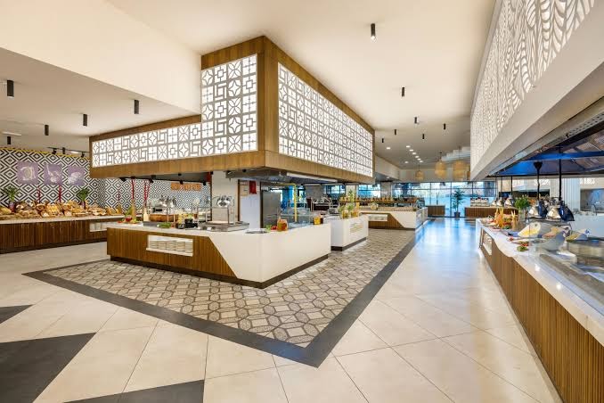 Jacaranda Luxury Resort bufetes tipa restorāna interjers ar plašu ēdienu izvēli un modernu apgaismojumu
