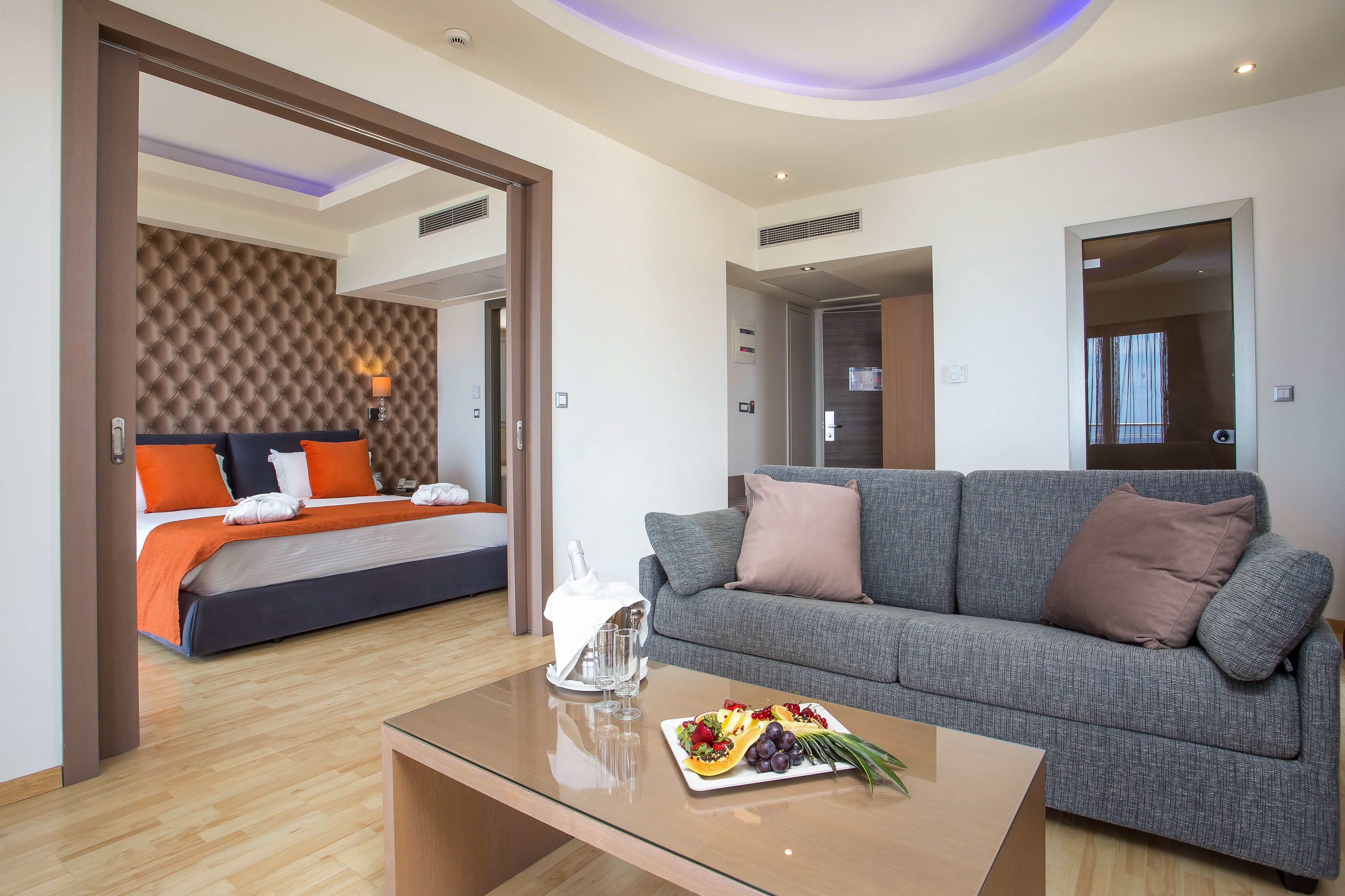 Eleganti numurs Pegasos Beach Hotel & Resort ar dīvānu un augļu šķīvi.