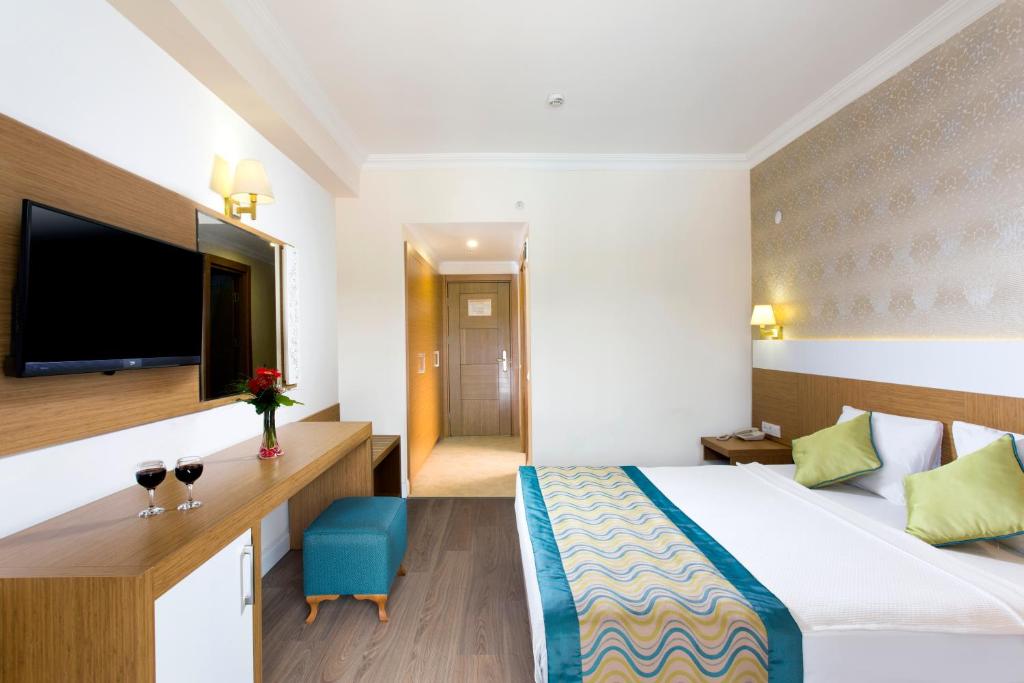 Elegants numurs Kemer Dream Hotel ar televizoru un vīna glāzēm uz galda