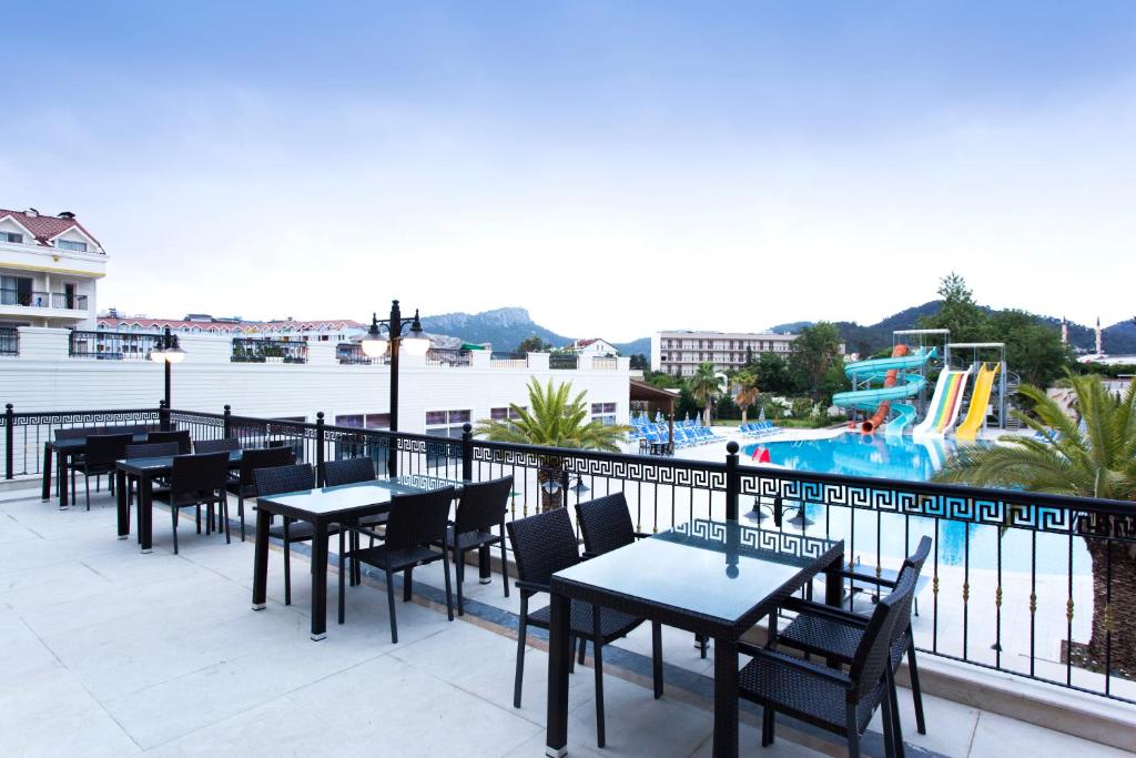 Kemer Dream Hotel terase ar galdiem un skatu uz baseinu un ūdens slidkalniņiem.