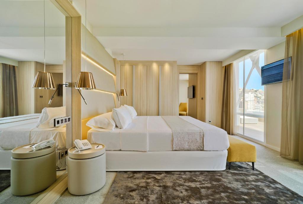 Mūsdienīgs viesnīcas numurs ar plašu gultu, koka apdari un elegantiem gaismas ķermeņiem, kas rada patīkamu atmosfēru. Lielas logu vitrīnas nodrošina dabisko apgaismojumu un skatu uz ārpusi.