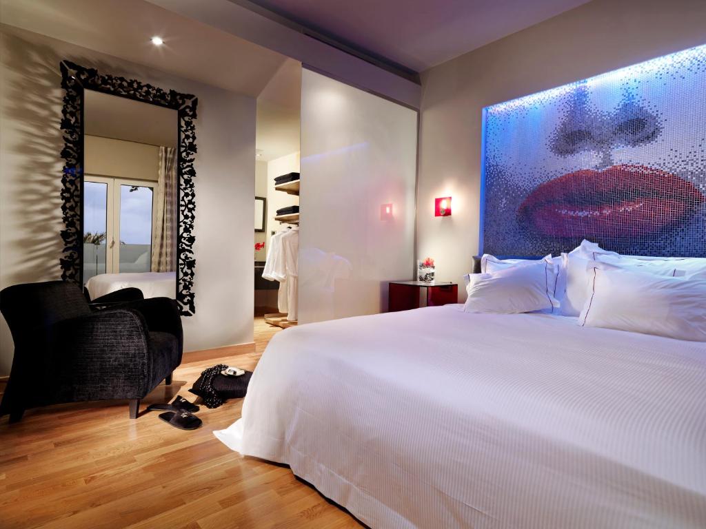 Mūsdienīgs viesnīcas numurs ar gultu un māksliniecisku sienas dekoru.