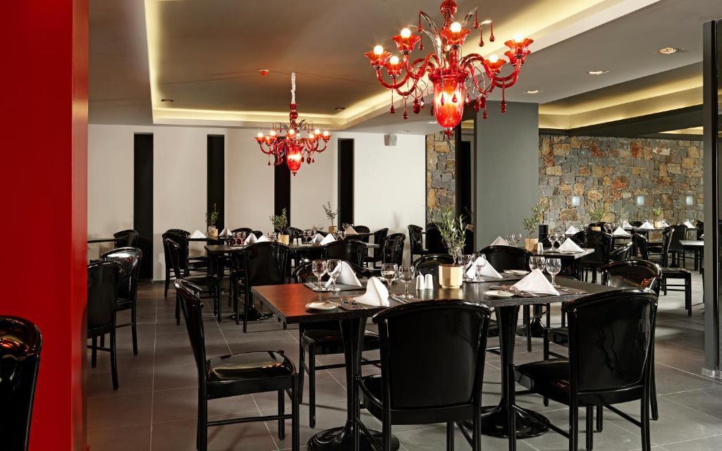 Elegants restorāns ar melnām mēbelēm un sarkaniem lustriem.