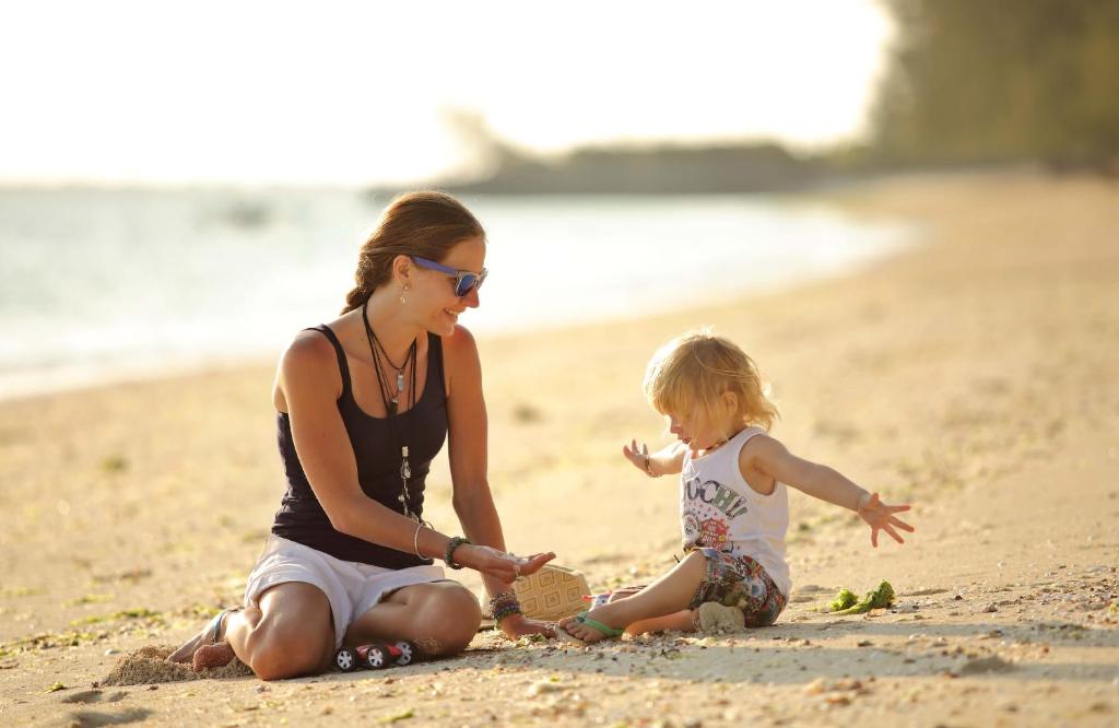 Sieviete ar bērnu pludmalē pie The Residence Zanzibar.