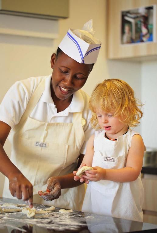 Bērns un darbinieks gatavo kopā The Residence Zanzibar virtuvē.