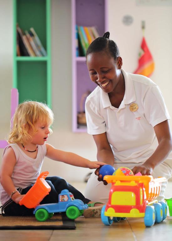 Aukle spēlējas ar bērnu The Residence Zanzibar bērnu klubā