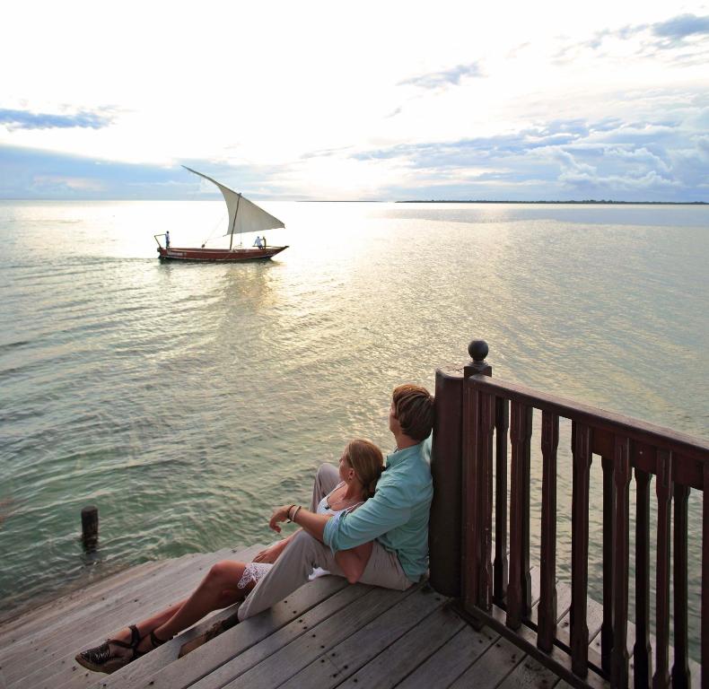 Pāris pie ūdens The Residence Zanzibar saulrietā.