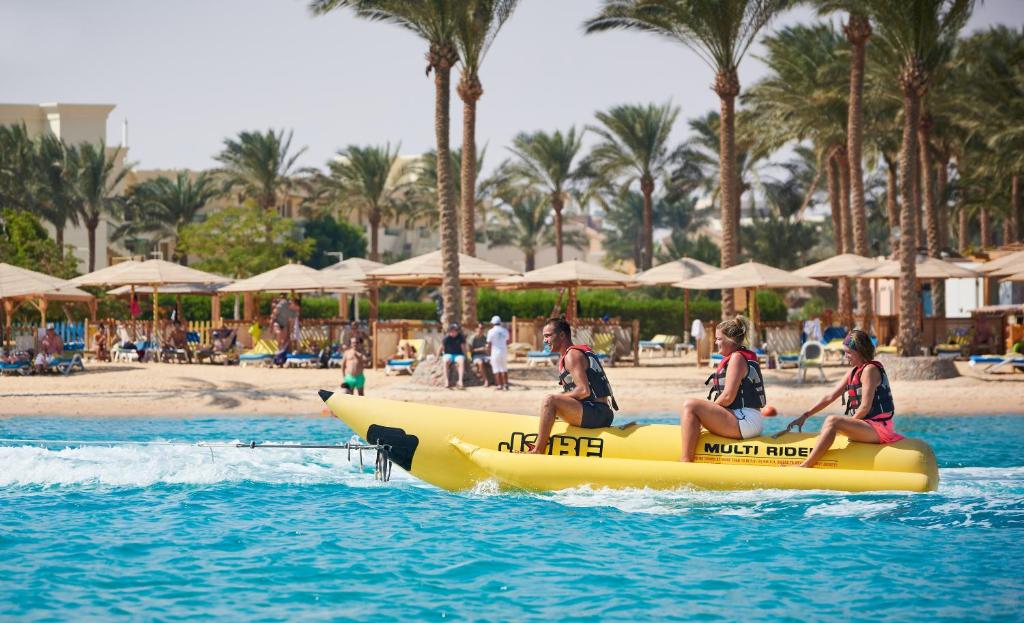 Viesnīcas Continental Hotel Hurghada pludmalē, cilvēki izklaidējas uz banāna laivas.