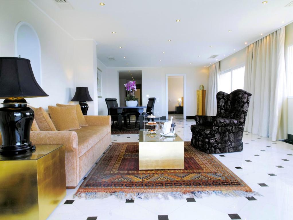 Eleganta viesistaba ar dīvānu, galdu un melnu lampu.